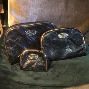 Three matching black leather make up bags